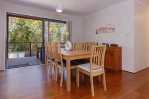 ein Esszimmer mit einem Holztisch und Stühlen in der Unterkunft Barrels at Boomerang in Boomerang Beach