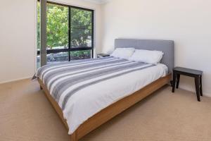 ein Schlafzimmer mit einem großen Bett mit einem großen Fenster in der Unterkunft Barrels at Boomerang in Boomerang Beach