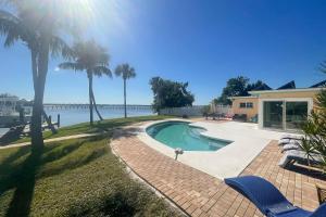 uma piscina com palmeiras e água em Pool, Dock and Kayaks Waterfront Palmetto Home em Palmetto