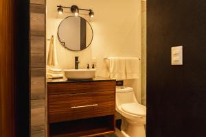 ein Badezimmer mit Waschbecken, Toilette und Spiegel in der Unterkunft Casita Cobojo in Bucerías