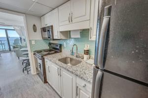 a kitchen with a sink and a refrigerator at Pets welcome,direct oceanfront, poolside,1 bedroom in Myrtle Beach