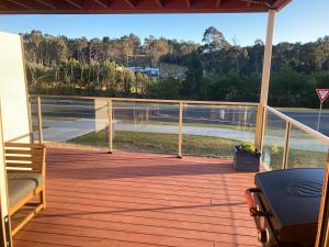 une terrasse avec un banc et une vue sur l'eau dans l'établissement Jimmies on Saltwood, à Tomakin