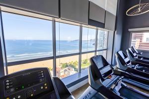 - une salle de sport avec vue sur la plage et l'océan dans l'établissement Stay Inn Santos Sua acomodação com cara de Hotel, à Santos