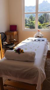 a bed with flowers on it in a room with a window at Hotel Integra Tepoztlán in Tepoztlán