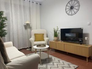 a living room with two chairs and a flat screen tv at Laurencia in Fuente Obejuna