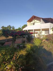 ein Haus mit Blumen und einer Bank davor in der Unterkunft Recanto Nova Vida in Ibiapina