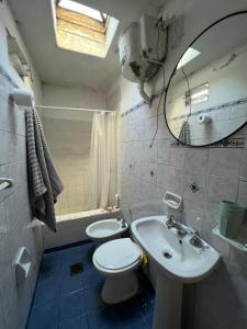 a bathroom with a toilet and a sink and a mirror at Refugio urbano frente al río, cómodo y moderno in Paraná