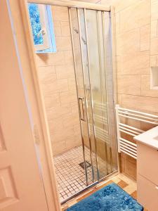 a shower with a glass door in a bathroom at Maison Bon Séjour in Livry-Gargan