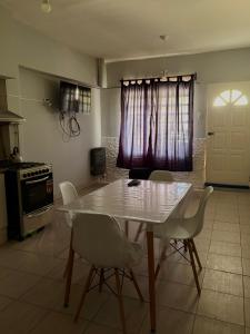 eine Küche mit einem weißen Tisch und Stühlen sowie einem Fenster in der Unterkunft Departamento simple y cómodo en Cipolletti in Cipolletti