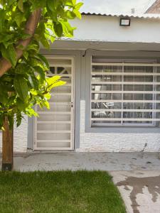 ein Haus mit zwei Garagentoren und einem Fenster in der Unterkunft Departamento simple y cómodo en Cipolletti in Cipolletti
