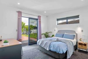 une chambre avec un lit et une porte coulissante en verre dans l'établissement 6 Bedrooms Hillside Lodge, à Rotorua