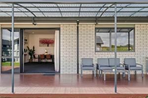 - une terrasse avec 2 chaises et une table dans un bâtiment dans l'établissement 6 Bedrooms Hillside Lodge, à Rotorua