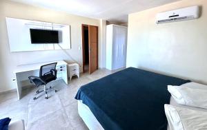 a bedroom with a bed and a desk and a chair at Eu Amo Arraial Hospedagem - Sophia I Orla Praia Grande in Arraial do Cabo