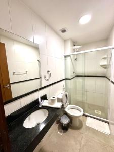 a bathroom with a sink and a toilet and a mirror at Eu Amo Arraial Hospedagem - Sophia I Orla Praia Grande in Arraial do Cabo