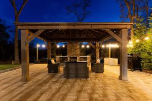 un pergolato con tavolo e sedie su un patio di notte di Ferrystone Lodge • Harpers Ferry Patio & Fireplace a Bolivar