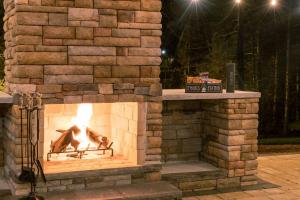 un camino in mattoni con un fuoco in esso di notte di Ferrystone Lodge • Harpers Ferry Patio & Fireplace a Bolivar