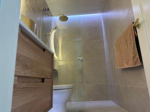 a bathroom with a toilet and a glass shower at Upscale neighbourhood guest quarters in Perth