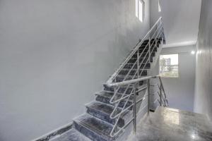 OYO Flagship Grand Mythri في Maula Ali: درج في منزل به سور معدني