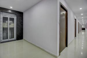 OYO Flagship Grand Mythri في Maula Ali: ممر فارغ مع باب في مبنى