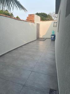 eine Betonterrasse mit einer Mauer und einem Gehweg in der Unterkunft Casa temporada in Cabo Frio