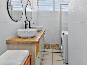 un bagno con lavandino e specchio di OFFRE NOËL ! Pied-à-Terre des Professionnels & Familles - Aéroport 12 min a Baie-Mahault