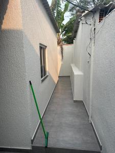 ein grüner Wischmopp, der an der Seite eines Gebäudes lehnt in der Unterkunft Casa temporada in Cabo Frio