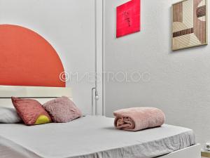 una camera da letto con un letto con cuscini rosa di OFFRE NOËL ! Pied-à-Terre des Professionnels & Familles - Aéroport 12 min a Baie-Mahault