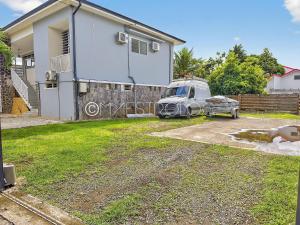un furgone parcheggiato in un vialetto di fronte a una casa. di OFFRE NOËL ! Pied-à-Terre des Professionnels & Familles - Aéroport 12 min a Baie-Mahault Altre 21 foto