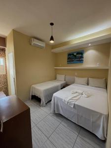 Un dormitorio con dos camas en una habitación. en Pousada Praia Dos Encantos, en Japaratinga 13 fotos más
