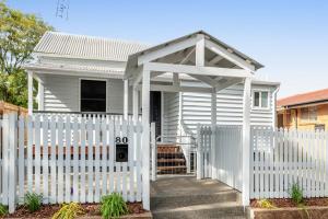 ein weißes Haus mit einem weißen Gartenzaun in der Unterkunft Stylish Inner-City Stay! in Toowoomba