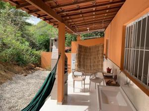 a patio with chairs and a hammock on a house at CASA da CHi in Piranhas