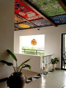 a room with a potted plant and colorful ceilings at No63 Amy's in Kandy
