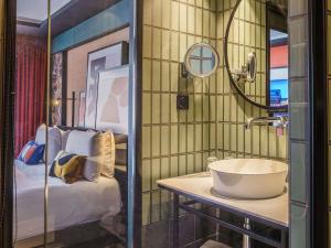 a bathroom with a sink and a bed at Mercure Dijon Centre Clemenceau in Dijon +182 photos