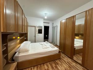 a bedroom with two beds and wooden cabinets at Eyar house in Kamëz