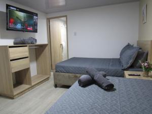 a bedroom with a bed and a tv on the wall at Lux Al Wafa in Bogotá +93 photos
