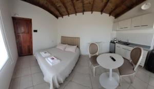 a room with a bed and a table and a kitchen at La iconica-tiny house in El Calafate