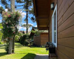 een huis met een raam en een bos met roze bloemen bij Chalé Bienz - Hospedagem Rural in Urubici