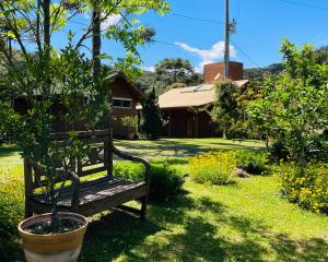 een bank in het gras voor een huis bij Chalé Bienz - Hospedagem Rural in Urubici +61 foto's