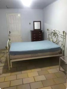 a bedroom with a bed and a dresser in a room at Casa de praia - 2 quadras do mar in Arroio do Sal