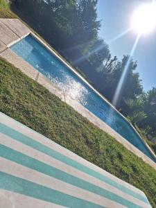 ein Schwimmbad mit blauen Stufen und die Sonne scheint in der Unterkunft Loft en las Sierras in Villa Giardino