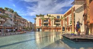 マラケシュにあるM Résidence Marrakech Luxury Serviced Apartmentsのヤシの木と建物が並ぶリゾート内のスイミングプール