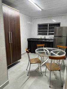 una cucina con tavolo, sedie e frigorifero di Casa Bertioga Centro a Bertioga