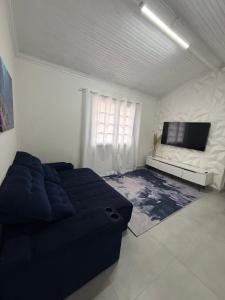 un soggiorno con un divano e una TV di Casa Bertioga Centro a Bertioga