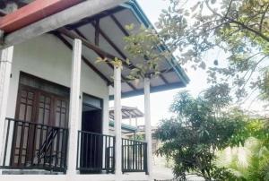 a house with a porch and a balcony at Misty Morning Villa Ella in Ella