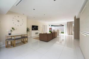 a living room with a couch and a clock on the wall at PLAYA a 3 minutos Parking barbacoa Apartamento en Castelldefels in Castelldefels