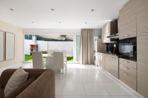 a kitchen and living room with a couch and a table at PLAYA a 3 minutos Parking barbacoa Apartamento en Castelldefels in Castelldefels +14 photos