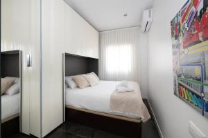 a small bedroom with a bed and a mirror at PLAYA a 3 minutos Parking barbacoa Apartamento en Castelldefels in Castelldefels