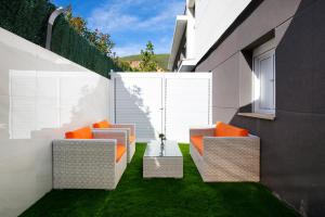 a patio with two chairs and a table at PLAYA a 3 minutos Parking barbacoa Apartamento en Castelldefels in Castelldefels