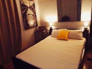 a bedroom with a bed with a yellow pillow at Cosy Appartement in Ouagadougou