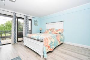 a bedroom with blue walls and a bed with a bedspread at Cedar Key Island Condo 228 in Cedar Key